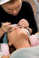 Procedure of eyelashes extension in beauty salon photo