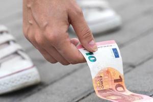 Woman is picking ten euro banknote from the ground photo