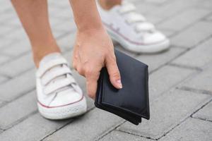 Woman found lost leather wallet on the ground photo