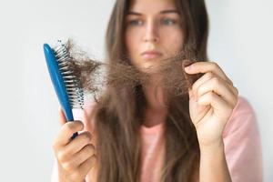 Young woman is upset because of hair loss photo