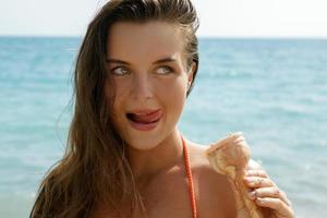 Woman with cone of ice cream on the beach photo