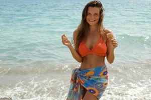 mujer con cono de helado en la playa foto