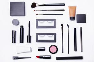 Different makeup objects and cosmetics on white photo