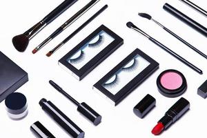 Different makeup objects and cosmetics on white photo