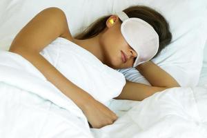 Woman is wearing eye mask and using earplugs photo