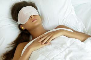 Woman is wearing eye mask and using earplugs photo