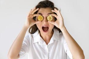 Young woman with a Bitcoin cryptocurrency on gray background photo