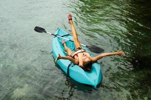 Happy young woman relax during lying in the kayak photo