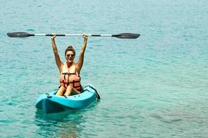 joven feliz haciendo kayak en el lago foto