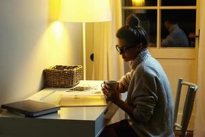 Woman wearing a warm woolen sweater is reading book photo