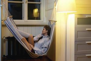 Woman wearing woolen pullover lying in the hammock photo