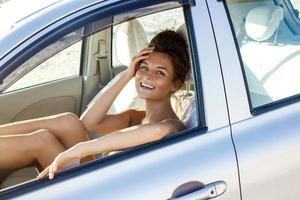 mujer con hermosa sonrisa está sentada en el auto foto