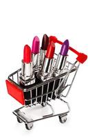 Shopping cart with a different lipsticks on white photo