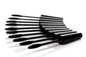 A lot of black Mascara wands on white background photo