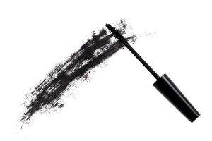 Black wand and smudged mascara on white background photo