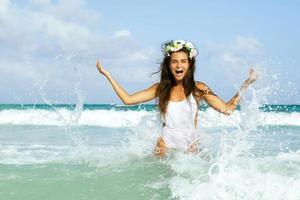 Happy woman playing and splashing in the sea photo