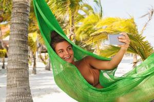 Happy and beautiful woman lying in the hammock photo