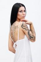 Woman with tattoos wearing beautiful nightgown photo