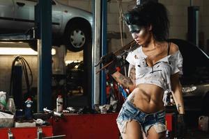 Female mechanic in the garage with artistic makeup on her face stylized like a dirty spot photo