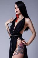 Portrait of woman with tattoos wearing black dress photo