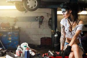 Female mechanic in the garage with artistic makeup on her face stylized like a dirty spot photo