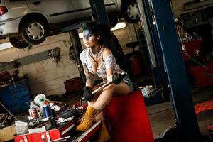 Female mechanic in the garage with artistic makeup on her face stylized like a dirty spot photo