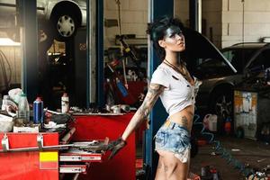 Female mechanic in the garage with artistic makeup on her face stylized like a dirty spot photo
