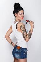 Young woman tattooist with a tattoo-machine in her hand photo