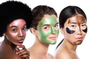 Beautiful multi-ethnic girls with colorful peel-off masks on their faces photo