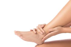 Woman is touching her injured ankle against white background photo