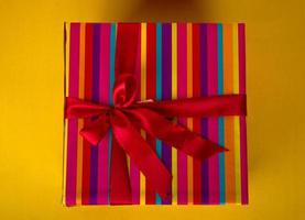 wrapped colorful gift on yellow background photo
