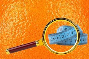 Diet, cellulite, orange peel texture concept image, skin with magnifying glass and blue centiment. photo