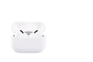 White wireless headphones in a storage and charging box. White, isolated, background photo