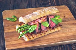 Sandwich with asparagus and slices of beef steak photo