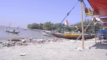 vue sur la plage qui sert de port où accostent les bateaux de pêche traditionnels video