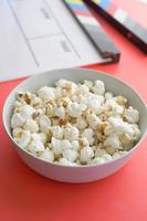 vertical shot of Movie clapper board and popcorn on table top view photo