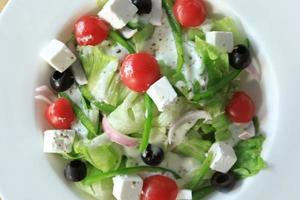 Close up of greek salad in a bowl on table. photo