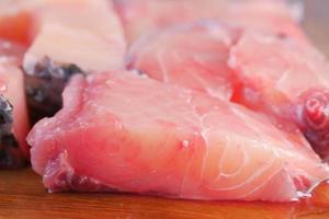 Fresh boneless skinless cod filet on chopping board photo