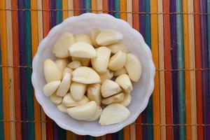 top view of slice of garlic in a bowl on table photo