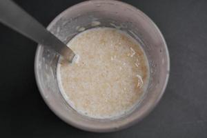 oats, banana and milk in a bowl on black background photo