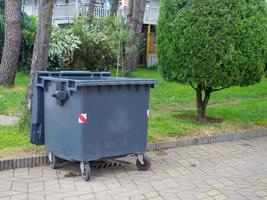 contenedor de basura en el parque. luchar por el medio ambiente. cubo de basura entre árboles verdes foto