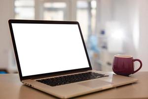 Close up Laptop Computer on Top of Office Table of a Businessman with Empty White Screen, Emphasizing Copy Space. photo