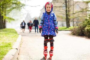 niña en patines bebiendo agua en el parque foto