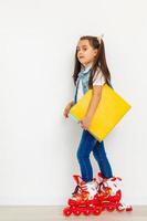 Cute girl on roller skates against white background photo