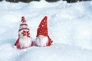 Christmas holiday card Cute scandinavian gnomes with red hat and white beard on snowy winter bench Fairytale snowfall Wintertime Hello December, January, February concept Happy New Year, Christmas photo