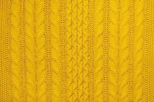 Bright yellow macro photo of textured jersey and knitting of sweater or sweatshirt. Pattern and background for fashion Warm Autumn concept