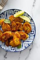 Fried caramelized plantains served with lime wedges photo