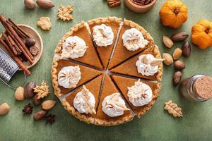 Traditional Thanksgiving pumpkin pie cut into slices photo