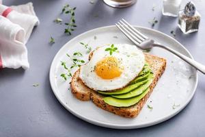 Avocado toast on a toasted multigrain bread with a fried egg photo