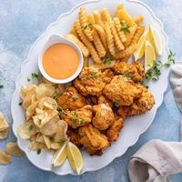 Fish and chips on a serving platter with dipping sauce photo